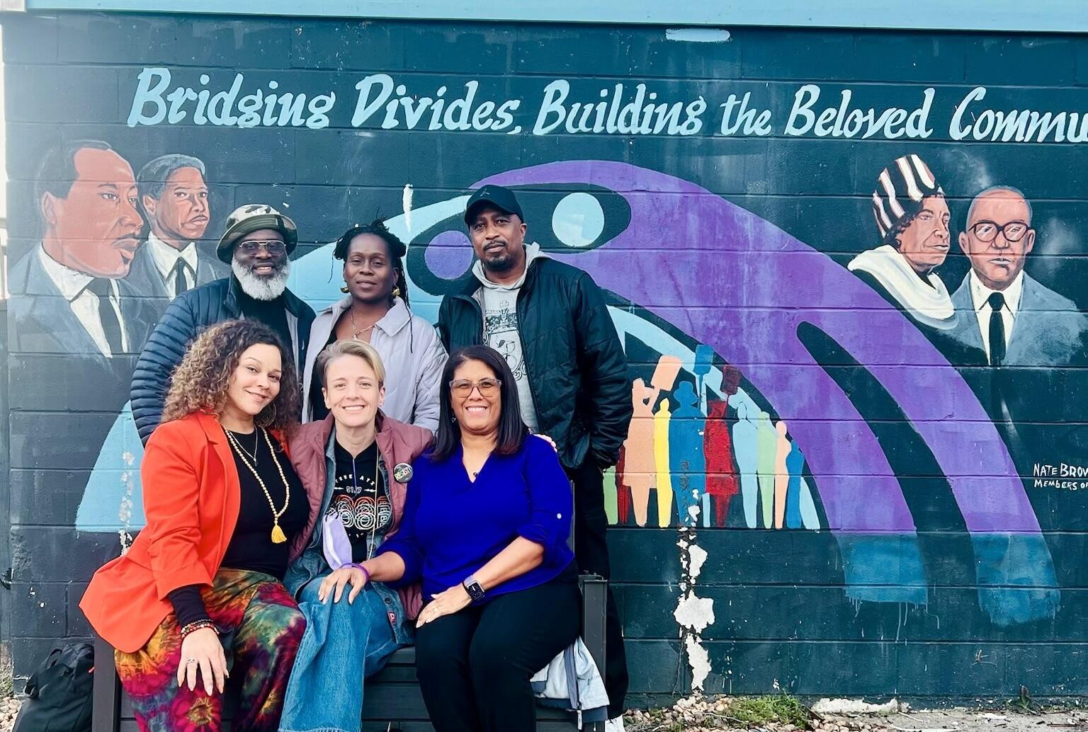 Nonviolent Austin trainers in front of the colorful mural at the Selma Center.