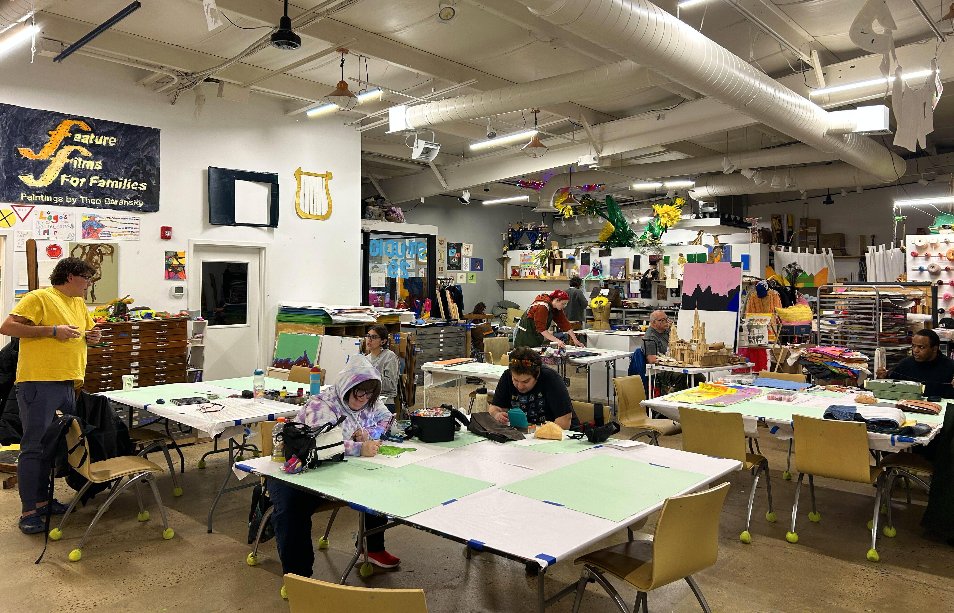 a group of people at work in a bright and colorful art studio space.