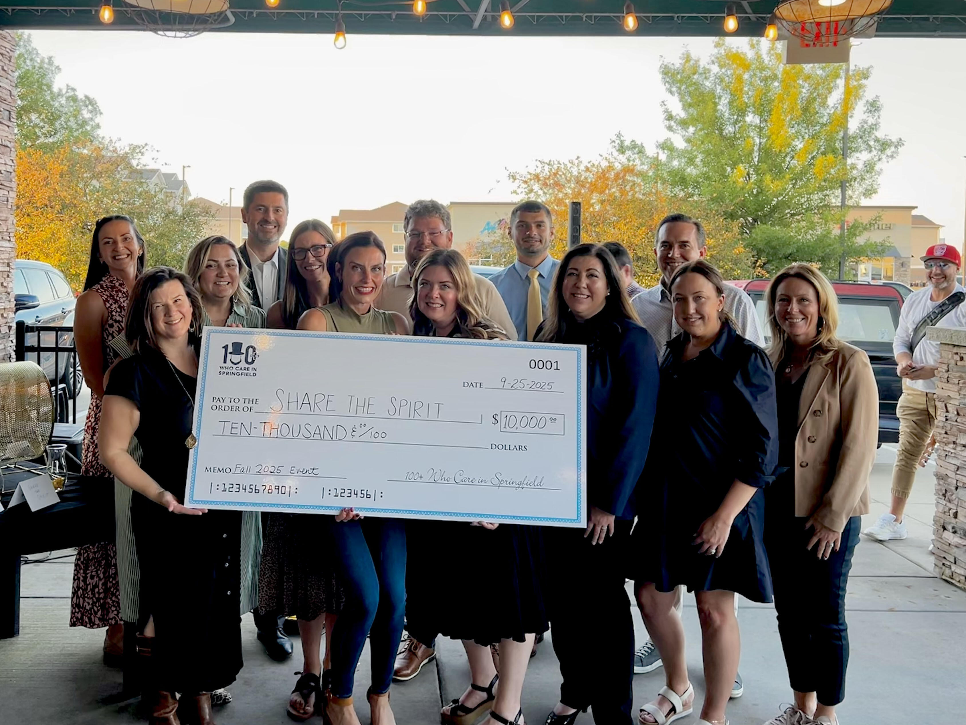 big check photo opp with Share the Spirit rep and 100+ board members
