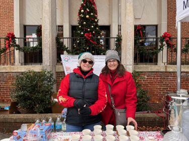 Friends of the Martinsburg Public Library Volunteers handing out hot cocoa during Christmas on Main